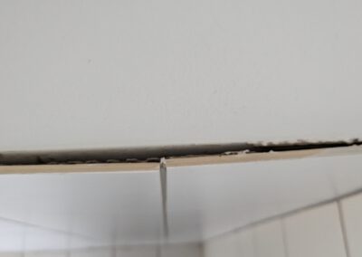 Wandfliesen lösen sich von der Wand ab.